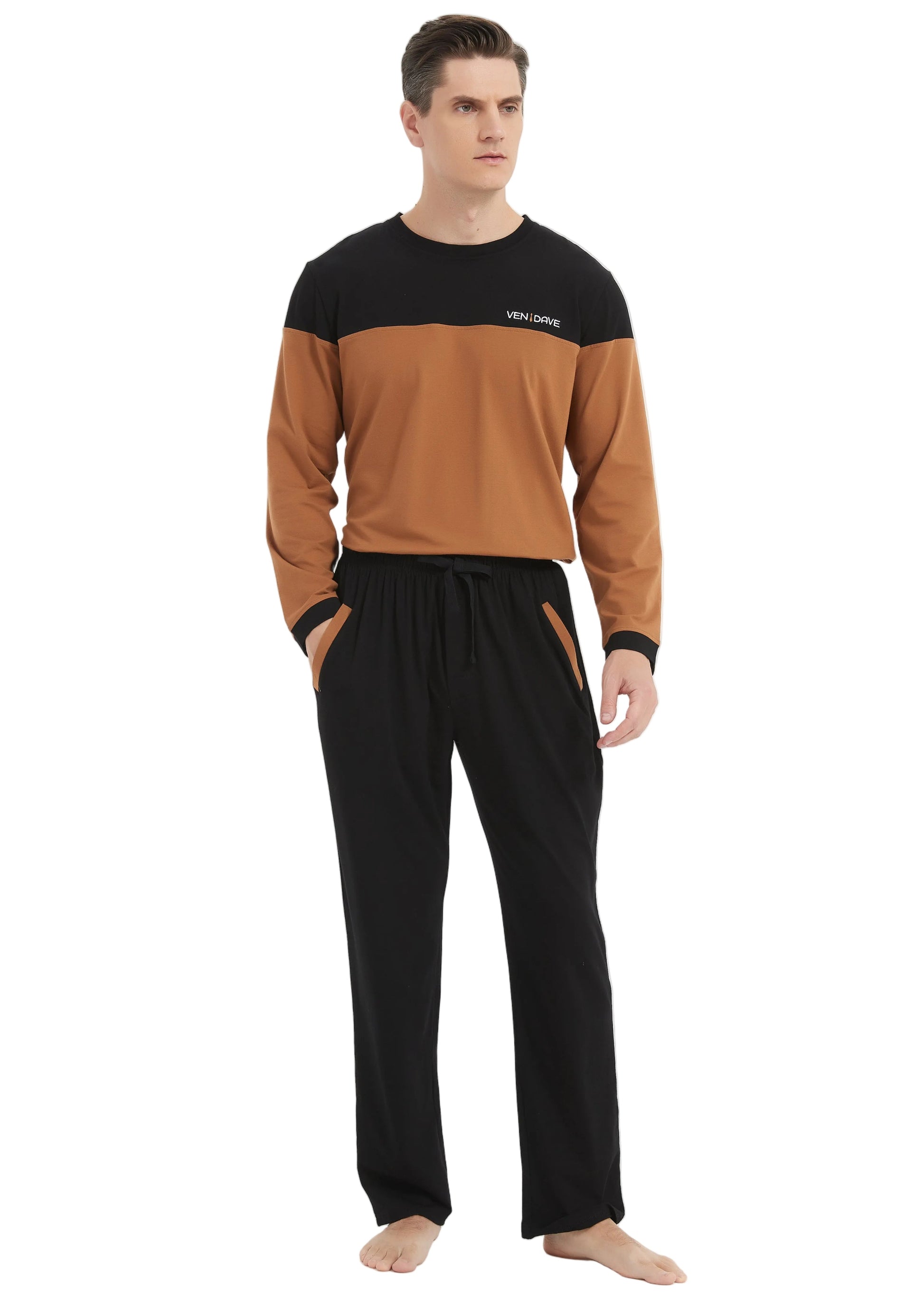 A man modeling a two-tone long-sleeve top and matching pants set. The top is color-blocked with black shoulders and sleeves and a warm brown body, featuring a small white logo on the chest.