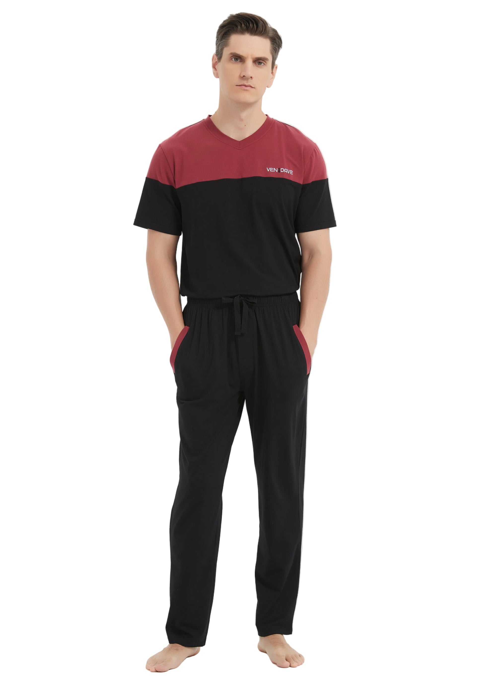 A man modeling a two-piece sleepwear set consisting of a short-sleeve V-neck shirt and matching drawstring pants. The shirt features a maroon upper chest and shoulders with black sleeves and body, while the pants are solid black with side pockets.