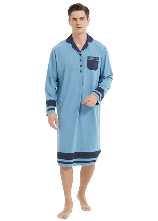 A man modeling a light blue long-sleeve pajama shirt with dark navy blue trim on the collar, cuffs, and hem, standing against a plain white studio background.