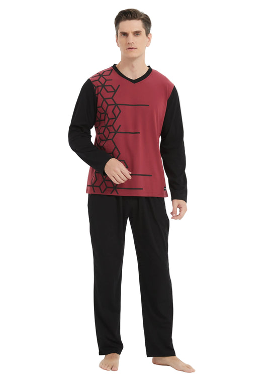 A man modeling a two-piece pajama set consisting of a long-sleeve top with a red and black geometric pattern and black pants, shot against a plain white studio background.