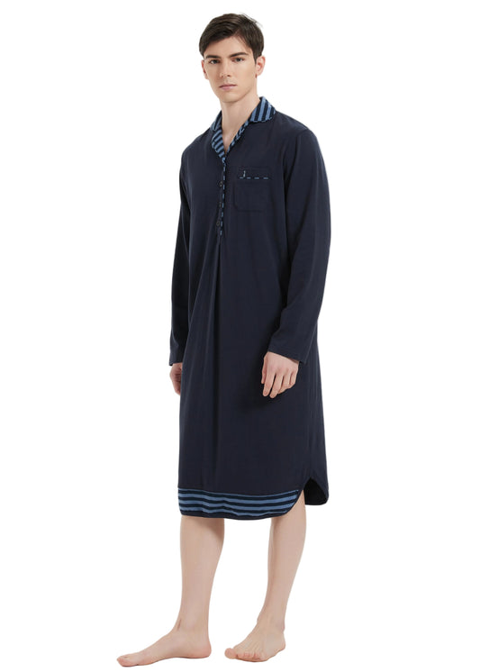 A man modeling a long-sleeved navy blue nightshirt with striped trim on the collar and hem, standing against a plain white studio background.