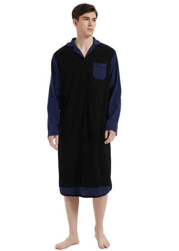 A man modeling a long-sleeve button-front robe or nightshirt in black with contrasting dark blue sleeves, collar, and chest pocket, photographed against a plain light gray studio background.