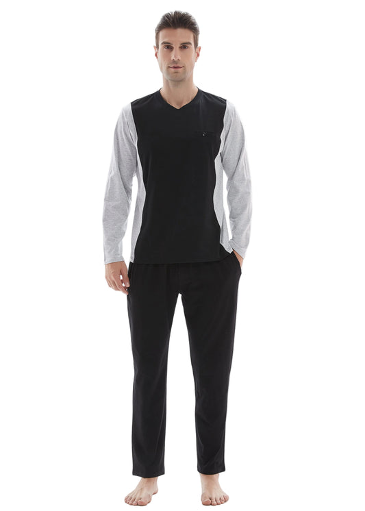 A man modeling a two-piece pajama set consisting of a black V-neck long-sleeve top with light gray sleeves and black pants, standing against a white studio background.
