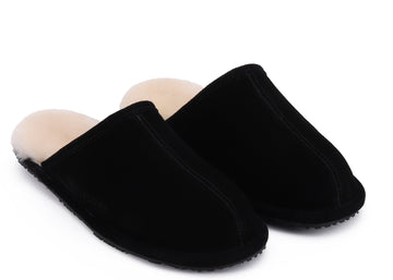 A pair of black slip-on mule slippers with a soft beige shearling-style lining, shown on a plain white background.