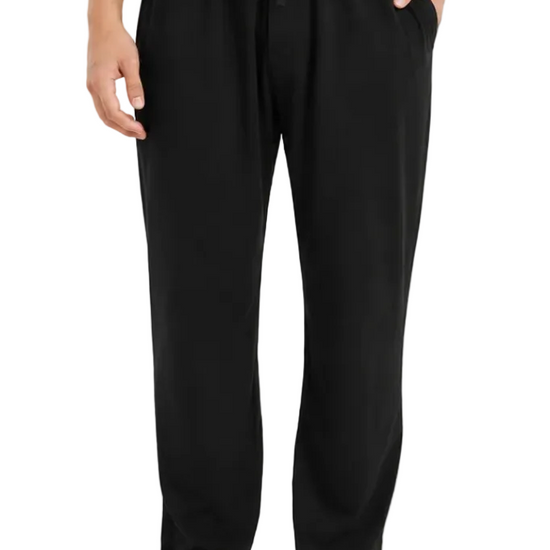 A person modeling black drawstring lounge pants against a clean white studio background.